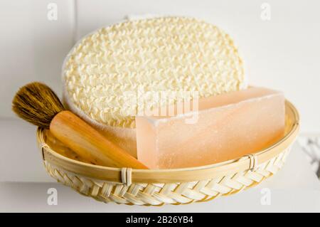 Bar of orange Himalayan crystal Salt Soap on wooden tray with cleaning bath sponge in bathroom. Stock Photo