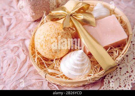 Natural bamboo material gift basket filled with shredded wood excelsior with various spa bathroom products, pink soap bar, bath bomb, natural sponge o Stock Photo