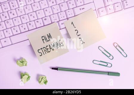 Handwriting text writing Film Streaming. Conceptual photo act of watching sound or video directly from the internet Square green note paper with penci Stock Photo