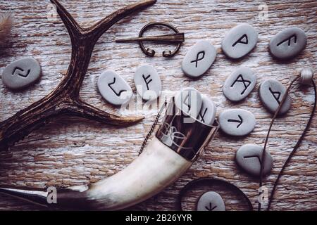 Flat lay view of rune stones with various viking era style objects. Ancient divination and vikings lifestyle concept. Stock Photo