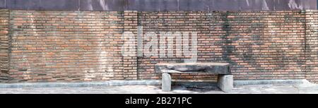 Long texture of red brick use for background images, The pattern of bricks with chair made of wood Stock Photo