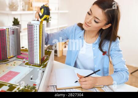 young talented architect performing construction drawings in the office room with modern interior. close up photo. horizontal shot. Stock Photo