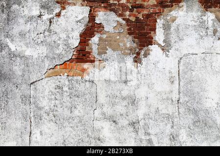 a faded white concrete wall with exposed red brick details with bright sunlight shadows Stock Photo