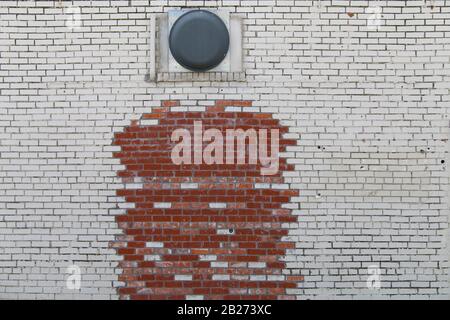 a retro peeling white paint and faded red brick alley wall Stock Photo