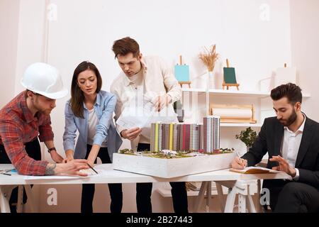 a group of young clever people works at the market of wooden housing construction, close up photo Stock Photo