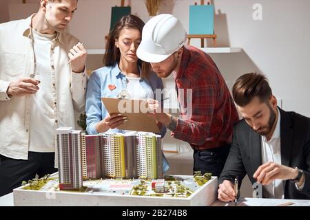 design services, talented professional designers team working on project, discussing functional space creation, decoration ideas Stock Photo