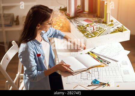 gorgeous architect spending time in the office developing drawing skills, close up side view photo. Stock Photo
