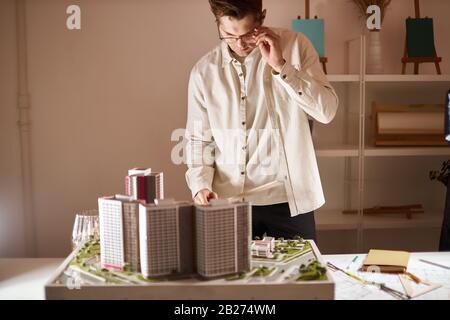 good looking man in glasses performing detailed accurate measuring, close up photo. Stock Photo