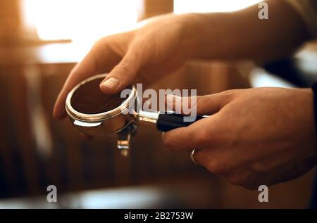 barista grounding coffee beans . close up side view photo, secret of making roasted fresh ground coffee, close up side view cropped photo Stock Photo