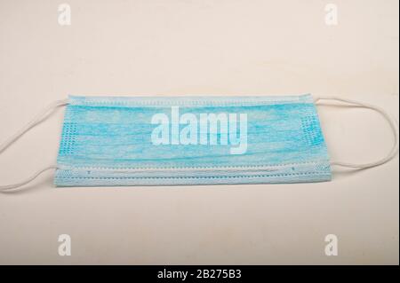 Disposable medical mask on a white background. Individual protection against infectious diseases. Close up Stock Photo