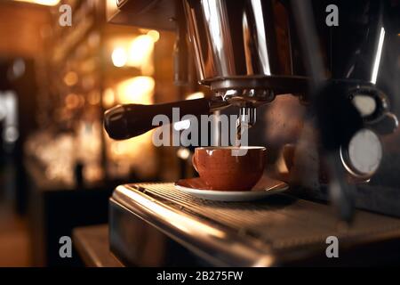 Fresh strong balc coffee prepared in the coffee machine. Espresso in small brown cup Stock Photo