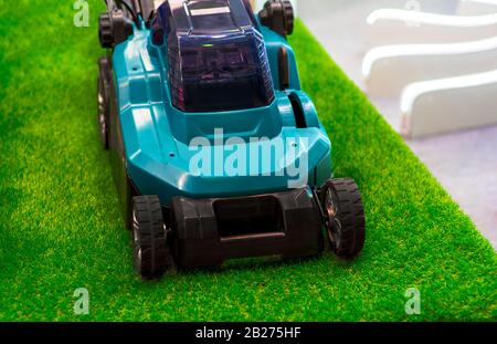 Turquoise lawn mower on grass. Stock Photo
