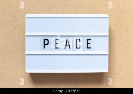 White lightbox with word peace on wood background Stock Photo
