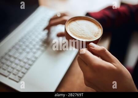 guy holding a cup of latte with heart , close up cropped photo. man adores hot espresso coffee Stock Photo