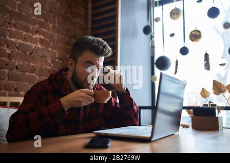 pleasant guy in eyeglasses reading information, news form the net, students preparing for exams. close up side view photo Stock Photo