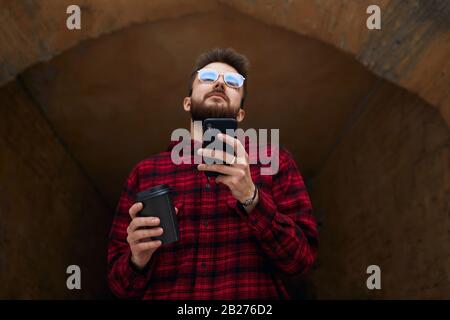 young bearded man sending message, typing text, close up low angle view. guy browsing the net , downloading music Stock Photo