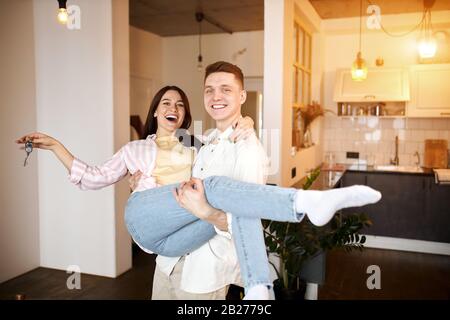 Happy excited cheerful couple celebrating new home,holding keys in hands, close up photo. happiness, positive feeling and emotion Stock Photo