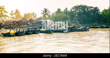 Row boats by a village on the shore of Karnaphuli River near Chittagong, Bangladesh Stock Photo