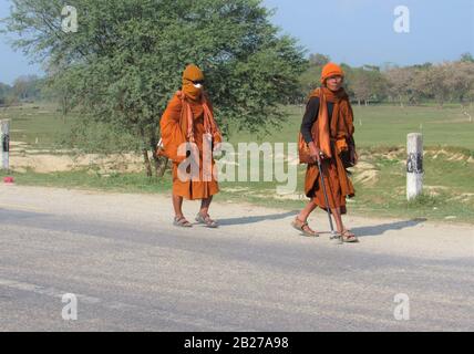 Buddhist Monks Walking along a Road, Rohini Rural Municipality Area, Rupandehi, Western Terai, Nepal, South Asia Stock Photo