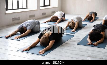 Group of diverse people lying on mats performing Child pose Stock Photo
