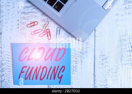 Writing note showing Cloud Funding. Business concept for Financiers combine social networking with project fundraising Trendy metallic laptop blank st Stock Photo