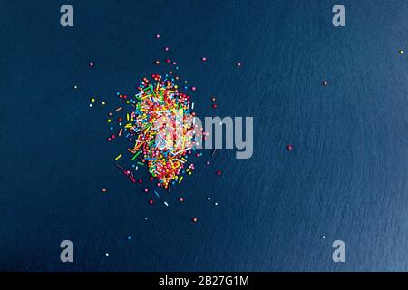 Multicolor candies on stone dark blue background. Top view with copyspace Stock Photo