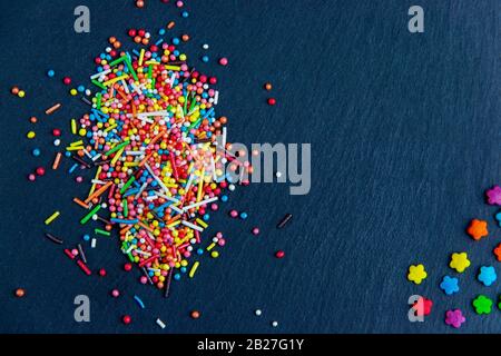 Multicolor candies on stone dark blue background. Top view with copyspace Stock Photo