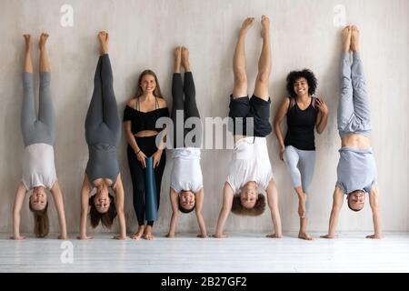 Multiethnic strong sportive people in sportswear standing posing near wall Stock Photo