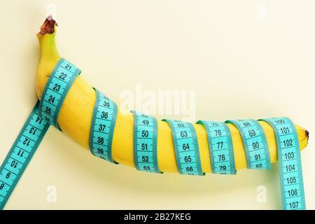 https://l450v.alamy.com/450v/2b27keg/centimeter-ruler-spinned-around-fresh-fruit-blue-tape-wrapped-around-banana-isolated-on-white-background-weight-loss-healthy-food-and-slim-body-concept-banana-with-tape-for-measuring-figure-2b27keg.jpg