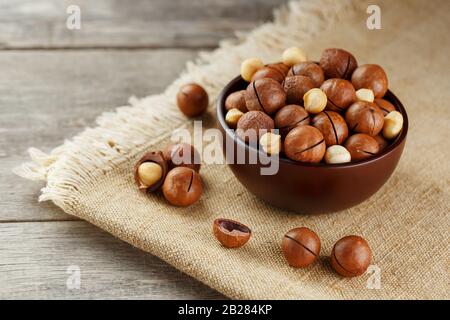 Macadamia nut on wooden background with vintage cloth, concept of superfoods and healthy food Stock Photo