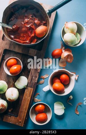 Dyeing eggs for Easter holidays, coloring with different color and tonality using natural food dye pigment and painting color, over a white  backgroun Stock Photo