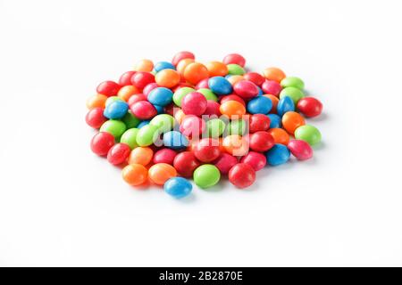 A rainbow of colors from multicolored candies close-up, multi-colored glaze dragee on a white background isolated Stock Photo