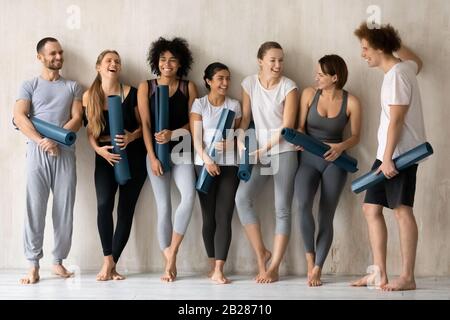 Young multiethnic people wear stylish activewear ready for yoga class Stock Photo