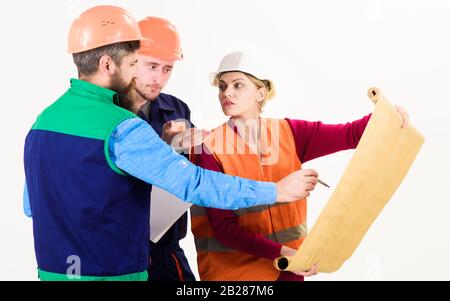 Men and woman in helmets, architects on busy faces looks at drawing, plan, blueprint, project, white background. Team of builder, engineer, architect work on project. Plan of build concept. Stock Photo
