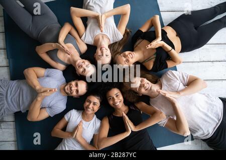 Above view people in sportswear lying on mats showing Namaste Stock Photo