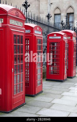 a line of four old red British telephone boxes in London, England. Stock Photo