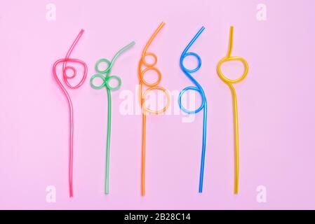 Top above overhead high angle view photo of five different colorful twisted in shapes cocktail straws isolated over pastel background Stock Photo