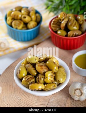 Wooden background with green olives, olive oil, garlic and spices Stock Photo