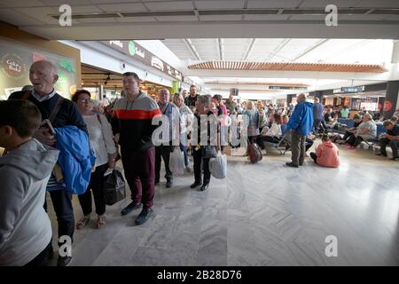 british and irish passengers queue at gate for flight home after winter sun break half term terminal t1 arricife cesar manrique-Lanzarote airport Stock Photo