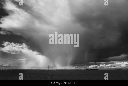 Dramatic rain or hail cloud over a field in Isle of Thanet, Kent in monochrome Stock Photo
