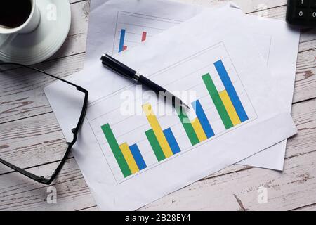 top view of financial chart, tea and pen on table  Stock Photo