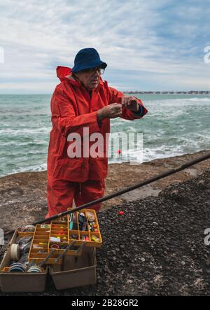 Close-up of a fisherman putting on bait with fishing equipment box. Fishing and sport concept. Stock Photo