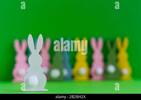 white wooden rabbit with colorful rabbits on background. Stock Photo