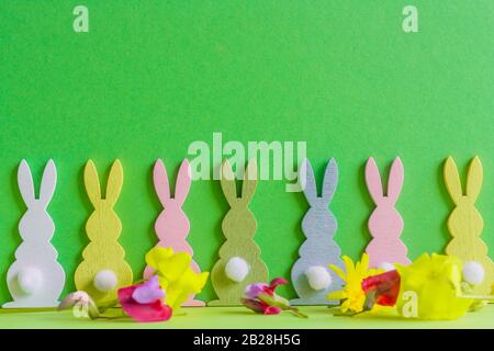 wooden colorful rabbits with country frlowes on green bacground for ester holiday. Stock Photo