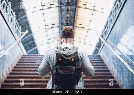 traveler man with backpack walking up by stairs Stock Photo