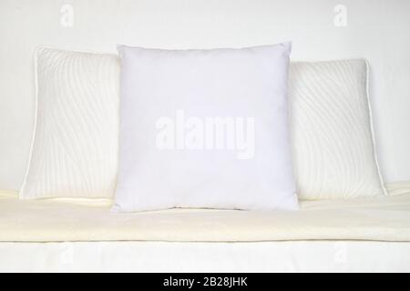 White Throw Pillow Mockup on Plush White Couch Stock Photo