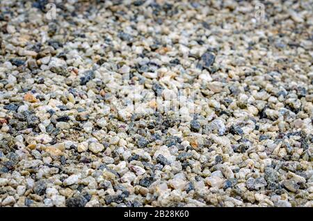 Multi-colored, smooth pebbles on the ground as a background. Stock Photo
