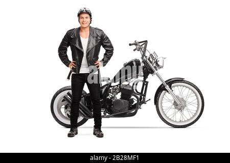 Full length portrait of a biker posing next to a customized chopper motorbike isolated on white background Stock Photo