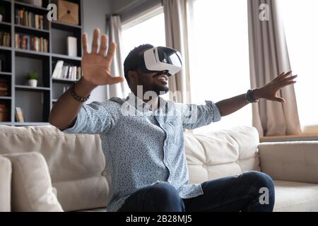 Overjoyed young guy enjoying spending time in virtual reality. Stock Photo