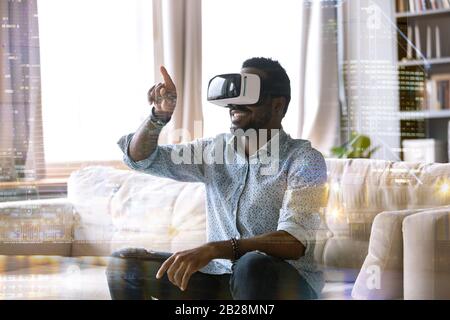 Excited young african american man wearing virtual reality glasses. Stock Photo